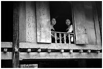 Two thai women at the window of their stilt house, Ban Lac village. Northwest Vietnam (black and white)