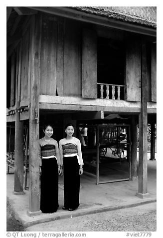 Two thai women standing in front of their stilt house, Ban Lac village. Northwest Vietnam (black and white)