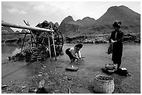 Thai women washing laundry and collecting water plants near an irrigation wheel, near Son La. Northwest Vietnam (black and white)