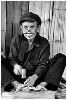 Black Dzao man making the decorative coins used in the children hats, between Tam Duong and Sapa. Northwest Vietnam (black and white)