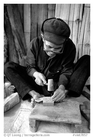 Dzao man crafting the decorative coins used in the children hats, between Tam Duong and Sapa. Northwest Vietnam (black and white)