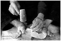 Hands and feet of a Black Dzao man making decorative coins, between Tam Duong and Sapa. Northwest Vietnam (black and white)