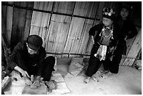 Black Dzao children look at a man  making the decorative coins used on their hats, between Tam Duong and Sapa. Northwest Vietnam (black and white)