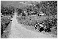 Family carrying logs walking towards their village, between Tuan Giao and Lai Chau. Northwest Vietnam (black and white)