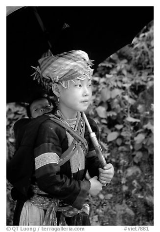 Hmong girl sheltering herself and her younger sibling with an unbrella, between Lai Chau and Tam Duong. Northwest Vietnam