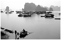 Rowboat meeting woman on shore. Halong Bay, Vietnam (black and white)