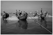 Fishermen get their nets out of their small fishing boats. Vung Tau, Vietnam (black and white)