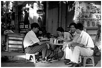 Enjoying a cafe on the streets, sitting on the typical tiny chairs. Ho Chi Minh City, Vietnam ( black and white)