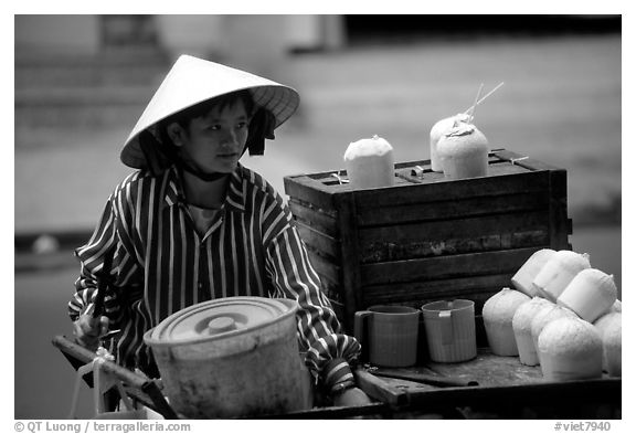 Coconut street vendor. The sweet juice is drank directly from a straw.. Ho Chi Minh City, Vietnam (black and white)