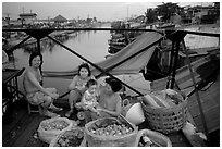 Family selling fruit on a bridge. Cholon, Ho Chi Minh City, Vietnam (black and white)