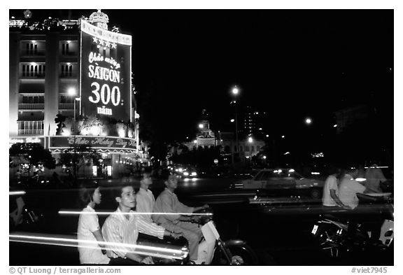 Night traffic in front of a sign celebrating the 300 years of Saigon. Ho Chi Minh City, Vietnam (black and white)