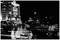 Night traffic in front of a sign celebrating the 300 years of Saigon. Ho Chi Minh City, Vietnam (black and white)