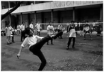 Students playing foot-only volley-ball in a school courtyard. Ho Chi Minh City, Vietnam (black and white)