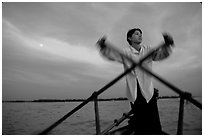 Boater using the X-shaped paddle characteristic of the Delta, sunset. Can Tho, Vietnam (black and white)