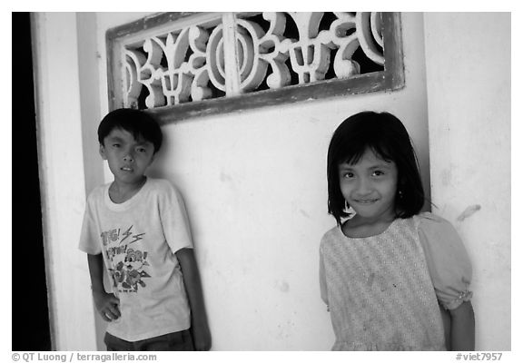 Two kids in front of a wall. Ben Tre, Vietnam (black and white)