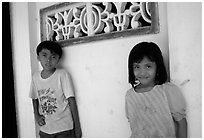 Two kids in front of a wall. Ben Tre, Vietnam (black and white)