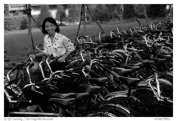 Woman retrieving her bicycle from a bicyle parking area. Mekong Delta, Vietnam (black and white)