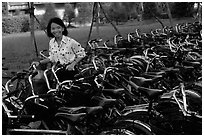 Woman retrieving her bicycle from a bicyle parking area. Mekong Delta, Vietnam (black and white)