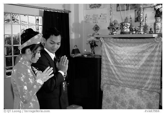 Newly-wed couple prays at the groom's ancestral altar. Ho Chi Minh City, Vietnam (black and white)