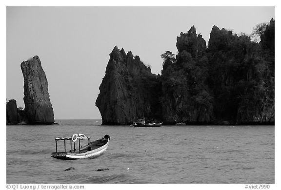 Small boats and offshore rock formations. Hong Chong Peninsula, Vietnam (black and white)