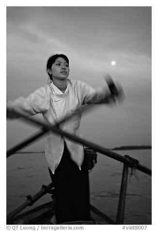 Woman using X-shaped paddles on the Mekong river, Can Tho. Vietnam (black and white)