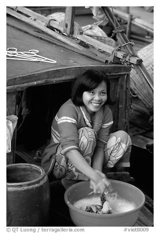 Woman doing laundry on live-aboard boat, the cheapest and most convenient housing in the Delta, near Can Tho. Vietnam (black and white)