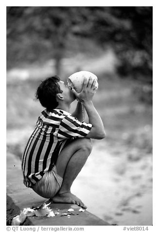 Drinking fresh coconut juice, cheaper than bottled water. Hong Chong Peninsula, Vietnam