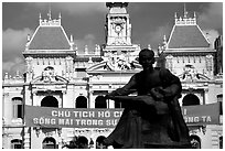 Bronze memorial to Ho Chi Minh by artist Diep Minh Chau and city hall. Ho Chi Minh City, Vietnam (black and white)