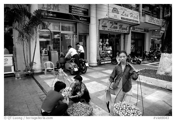 Old and new: street fruit vendors and computer store. Ho Chi Minh City, Vietnam (black and white)