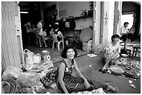 Old and new: street vendors and kids playing in a video games store. Ho Chi Minh City, Vietnam ( black and white)