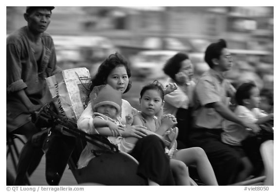 Wheels are seldom for single drivers: families on cyclo and motorbike. Ho Chi Minh City, Vietnam (black and white)