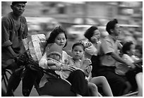Wheels are seldom for single drivers: families on cyclo and motorbike. Ho Chi Minh City, Vietnam ( black and white)