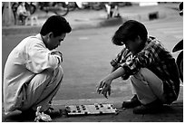Chinese Chess game. Vietnamese people can sit on their heels for hours. Ho Chi Minh City, Vietnam (black and white)