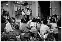 Watching TV on the street with the neighboors. Ho Chi Minh City, Vietnam (black and white)