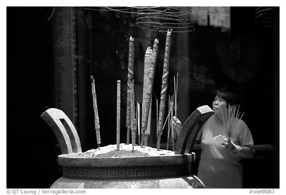 Offering incense at a Chinese temple in Cho Lon. Cholon, District 5, Ho Chi Minh City, Vietnam (black and white)