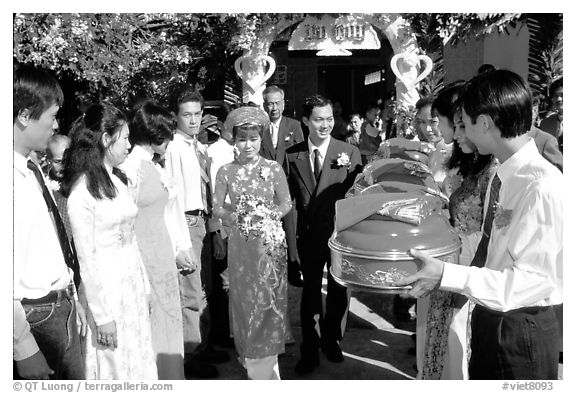 Exchange of gifts at wedding, upon exiting bride's home. The bride traditionaly wears red. Ho Chi Minh City, Vietnam (black and white)