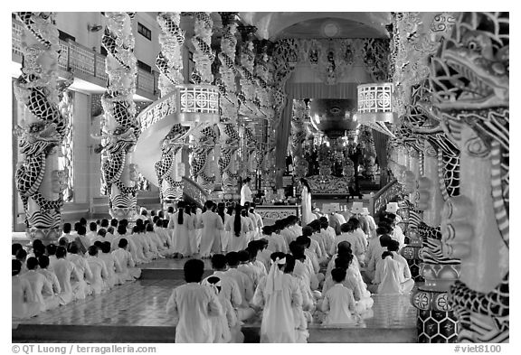 The noon ceremony, attended by priests inside the great Cao Dai temple. Tay Ninh, Vietnam (black and white)