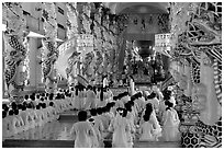 The noon ceremony, attended by priests inside the great Cao Dai temple. Tay Ninh, Vietnam (black and white)