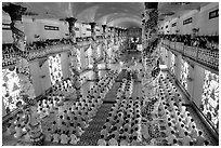 The noon ceremony, attended by priests inside the great Cao Dai temple. Tay Ninh, Vietnam ( black and white)