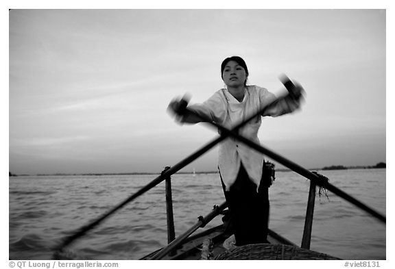 Woman using the X-shaped  paddle characteristic of the Delta. Can Tho, Vietnam