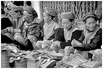 Women sell the colorful garnments after which the Flower Hmong are named. Bac Ha, Vietnam ( black and white)