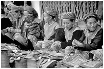 Women sell the colorful garnments after which the Flower Hmong are named. Bac Ha, Vietnam (black and white)