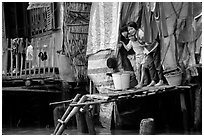 Children peering from their waterfront house. Can Tho, Vietnam (black and white)
