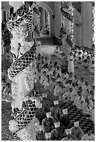 Priests and ornate columns inside the Great Caodai Temple. Tay Ninh, Vietnam (black and white)