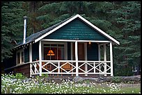 Cabin in forest with interior lights. Banff National Park, Canadian Rockies, Alberta, Canada ( color)