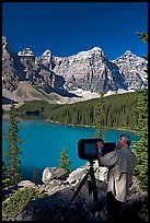 Photographer operating a 8x10 view camera at Moraine Lake. Banff National Park, Canadian Rockies, Alberta, Canada (color)