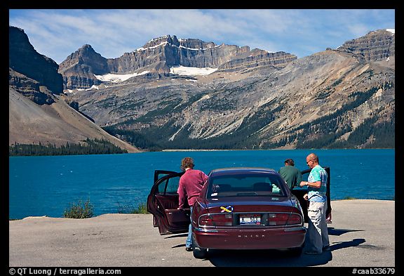 Tourists stepping out of a car next to Bow Lake. Banff National Park, Canadian Rockies, Alberta, Canada (color)