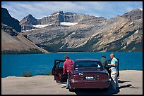 Tourists stepping out of a car next to Bow Lake. Banff National Park, Canadian Rockies, Alberta, Canada ( color)