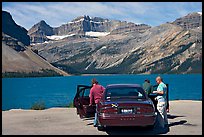 Tourists stepping out of a car next to Bow Lake. Banff National Park, Canadian Rockies, Alberta, Canada (color)