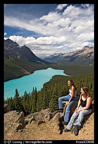 Women sitting on a rook overlooking Peyto Lake. Banff National Park, Canadian Rockies, Alberta, Canada (color)